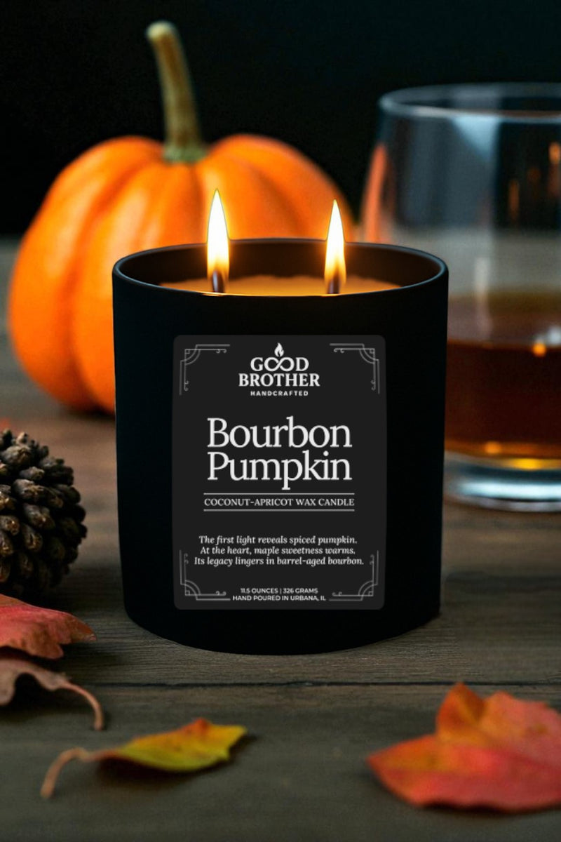 Candle labeled 'Bourbon Pumpkin' by Good Brother with a pumpkin and glass of bourbon in the background.