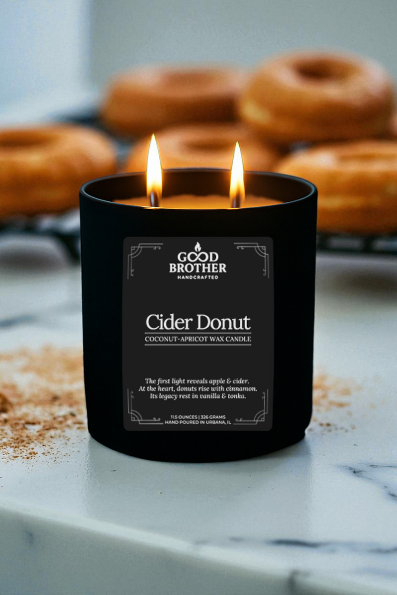Candle labeled 'Cider Donut' by Good Brother with donuts in the background