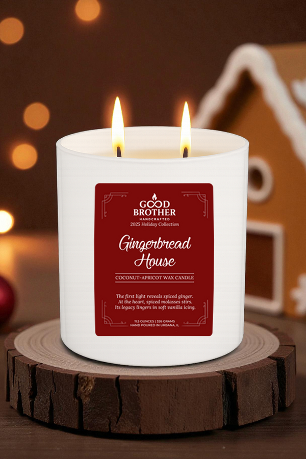 Candle labeled 'Gingerbread House' by Good Brother Handcrafted on a wooden circle with a festive background.