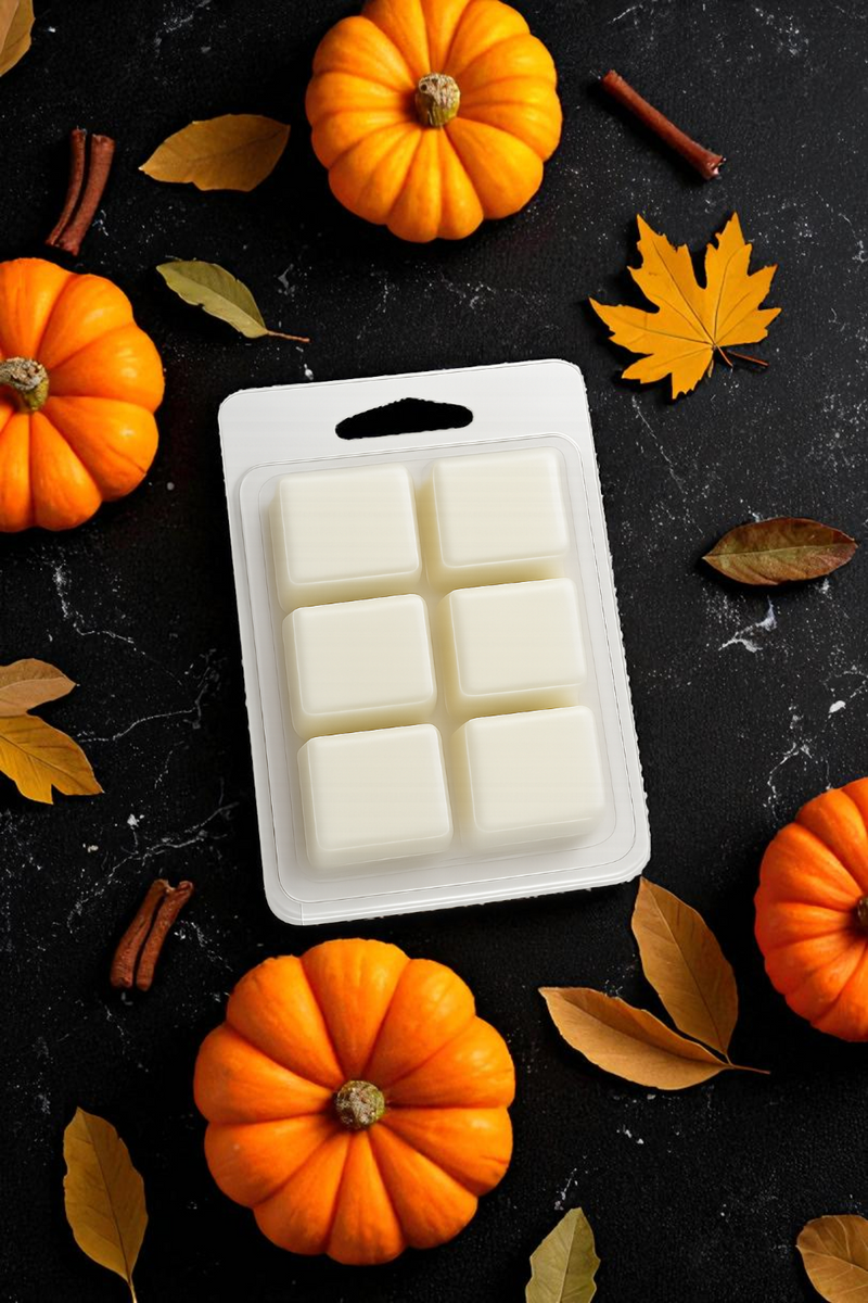 Pack of white wax melts on a black surface with pumpkins and leaves